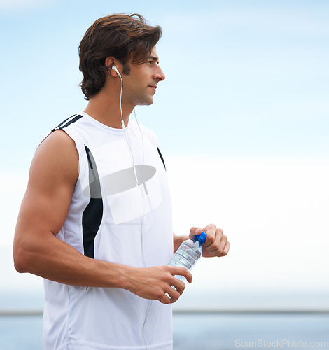 Image of Thinking, fitness and a man with water and music after running, exercise or outdoor cardio. Break, relax and a runner with a drink while listening to a podcast after training or sports in nature