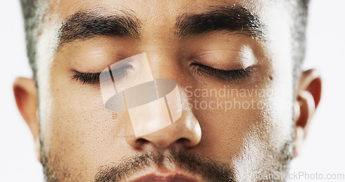 Image of Closeup, face and serious man in studio for skincare eyes closed, confident and handsome against white background. Zoom, young and portrait of Indian male model with wellness, beauty or cosmetic rout