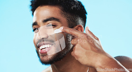 Image of Beauty, studio face and happy man with cream product for luxury makeup, facial cosmetics or acne protection. Dermatology lotion, collagen hydration creme or skincare model isolated on blue background