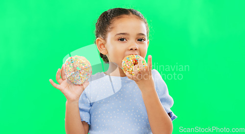 Image of Candy, smile and child eating donuts on green background with cake for party, birthday and luxury. Food, excited kid and isolated happy girl with sweets, dessert treats and sugar doughnuts in studio