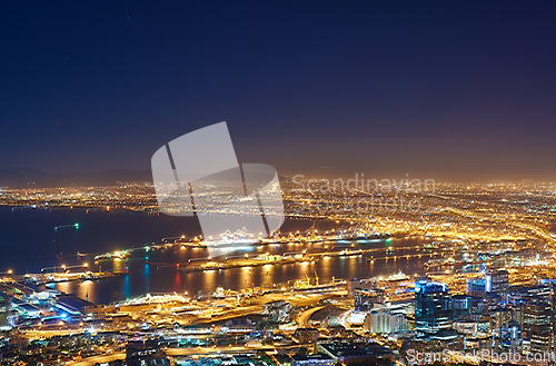 Image of Night, city and lights with landscape, buildings and urban development with traffic, transport and streets. Evening, dark and road with network, Cape Town and highway with water, growth and travel