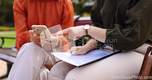 Image of Business, closeup and women on a bench, smartphone or planning for collaboration, documents or discussion. Female professionals, freelancers or partners in a park, cellphone or mobile app for project
