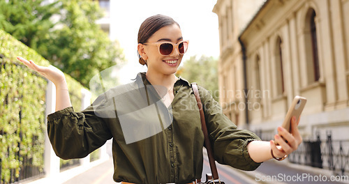 Image of Travel, video call and woman outdoor, smile or wave in street, tourist or excited for adventure. Female person, traveler sightseeing or girl with smartphone, live streaming or online for social media