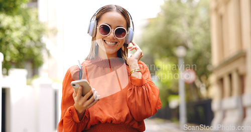 Image of Music headphones, phone and woman dancing in city, having fun or happiness outdoor. Cellphone, dancer and happy person listening, streaming and enjoying radio, audio or sound podcast in urban street.