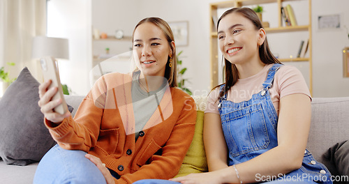 Image of Woman, friends and phone laughing on video call for funny joke, meme or communication at home. Women talking on mobile smartphone with laugh for silly conversation or discussion on living room sofa