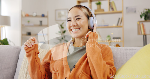 Image of Headphones, home and happy woman listening to music for mental health, youth radio and streaming on sofa. Young asian person or relax with audio technology in living room, couch or apartment for Kpop
