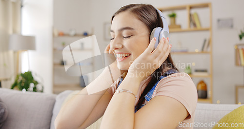 Image of Music, happy and woman with headphones, dance and motivation in living room, home and radio. Female model, girl and person with headset, streaming audio or sounds for inspiration, dancing or movement