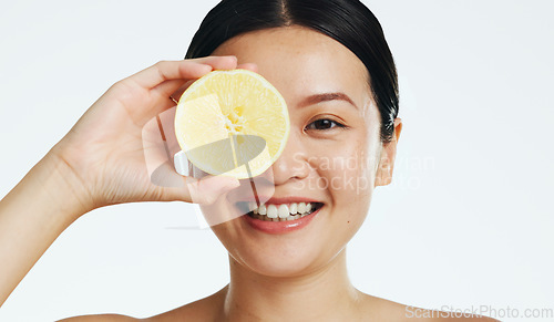 Image of Lemon, face and woman in studio, natural wellness and white background. Happy asian model, beauty portrait and citrus fruits for facial cosmetics glow, vitamin c skincare or detox dermatology results