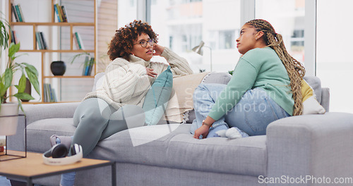 Image of Friends, women and talking on sofa, bonding in home living room and communication. Girls, friendship relax and smile of happy females chatting, speaking or discussion, sharing story or conversation.