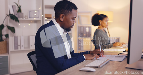 Image of Business, writing and black man with notebook by computer working late for planning, proposal and project. Corporate, focus and male worker at desk schedule, website research and online report notes