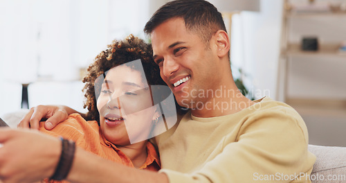 Image of Video, love and entertainment with a couple watching tv on a sofa in the living room of their home together. Relax, film or television with a man and woman streaming series on a subscription service