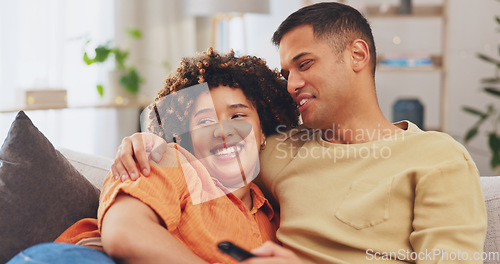 Image of Film, love and entertainment with a couple watching tv on a sofa in the living room of their home together. Relax, video or television with a man and woman streaming series on a subscription service