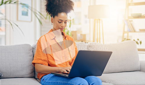 Image of Laptop, thinking and woman typing on sofa in home living room, working or social media. Computer, remote worker and happy mixed race person or freelancer writing email, research or online browsing.