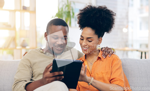 Image of Tablet, couple and smile on sofa in home living room, bonding and online shopping. Interracial, technology and happy black man and woman in love on social media, internet browsing or web scrolling.