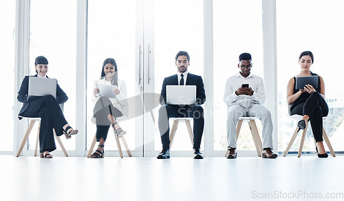 Image of Group, business people and chair with tech in queue, diversity or waiting room for hr recruitment. Men, women and technology for interview, human resources or research for hiring, job or opportunity