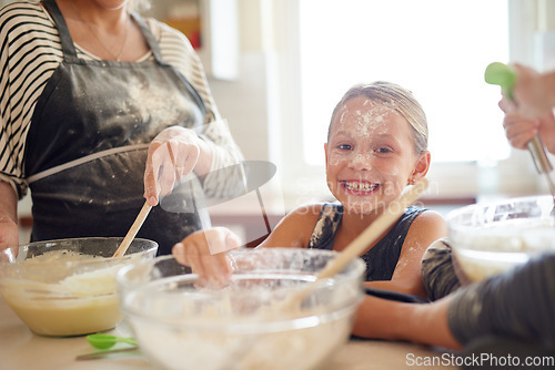 Image of Portrait, playing or messy girl baking in kitchen with a young kid smiling with flour on a dirty face at home. Smile, happy or parent cooking or teaching a fun daughter to bake for child development