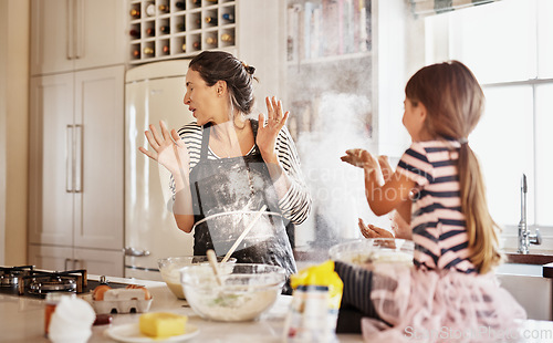 Image of Mother, playing or girl baking in kitchen as a happy family with a playful young kid with flour at home. Dirty, messy or funny mom helping, cooking or teaching daughter to bake for child development