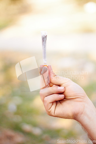 Image of Marijuana, cannabis or hand with weed joint for a calm peace to relax or help reduce pain, stress or anxiety. Trippy, smoking or closeup of person showing a blunt for mental health benefits outdoors