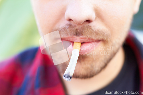 Image of Cigarette, smoke and man with a tobacco habit and addiction due to unhealthy or bad lifestyle outdoor. Mouth, cancer and lips of young person or male smoker with substance or healthcare problem