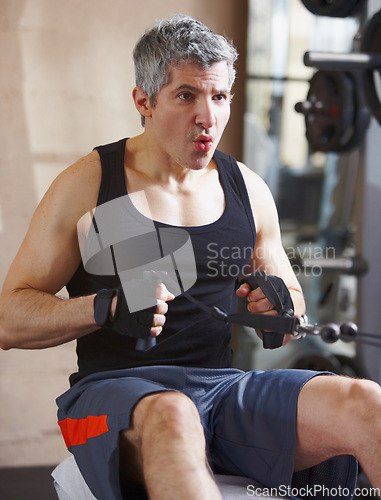 Image of Breathing, exercise and mature man with a cable row machine, workout goals and wellness with health, power and strong. Male person, athlete and gym equipment for training, progress and challenge