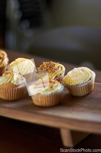 Image of Cupcake, dessert and bakery confectionery closeup, presentation and food with sweet baked goods. Luxury snack, frosting and sprinkles, hospitality and catering industry with cake on wooden table