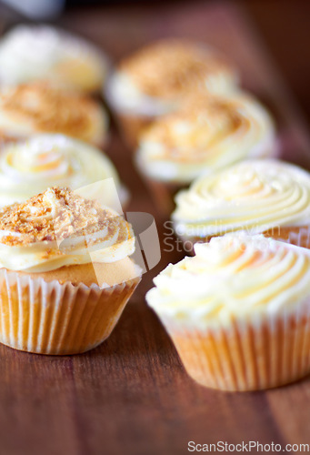 Image of Cupcake, dessert closeup and bakery presentation, food and confectionery with sweet baked goods. Luxury snack, frosting and sprinkles, hospitality and catering industry with cake on wooden table