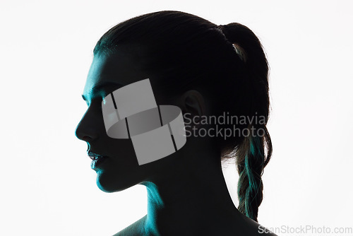 Image of Silhouette, studio and face of a woman on a white background with shadow and neon or creative glow in profile. Fantasy, light and shine of female model and side of person with art or dark aesthetic