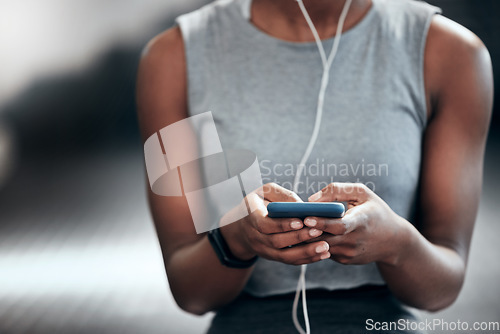 Image of Smartphone, hands or girl in gym on social media to relax on break after fitness training or workout break. Headphones, texting or healthy sports athlete with mobile app for online or digital content