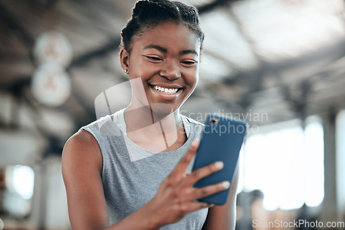 Image of Social media, happy or black woman with phone in gym to search for a sports blog in training or exercise. Fitness app, smile or healthy girl athlete relaxing or reading online mobile content on break