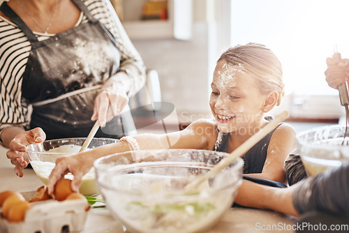 Image of Learning, playing or messy kid baking in kitchen with a young girl smiling with flour on a dirty face at home. Smile, happy or parent cooking or teaching a fun daughter to bake for child development