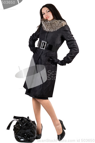 Image of The young woman in a black coat with a bag. Isolated