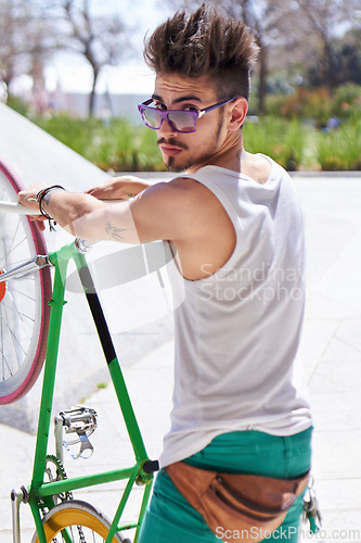 Image of Man, cool style and portrait with bike in city, outdoor and sunglasses for unique street fashion. Young gen z guy, funky male hipster and cycling on bicycle in summer, urban town and with attitude