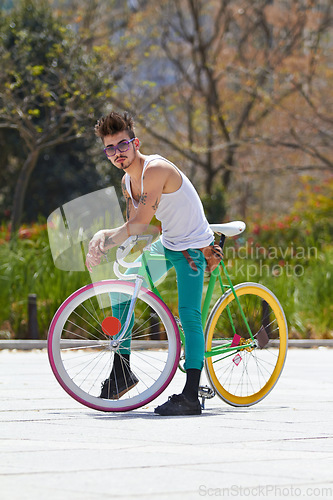 Image of Cool man, fashion and portrait with bicycle in city, outdoor and in sunshine with unique personality. Young gen z guy, funky trend and hipster cycling on bike in summer, urban town and with attitude