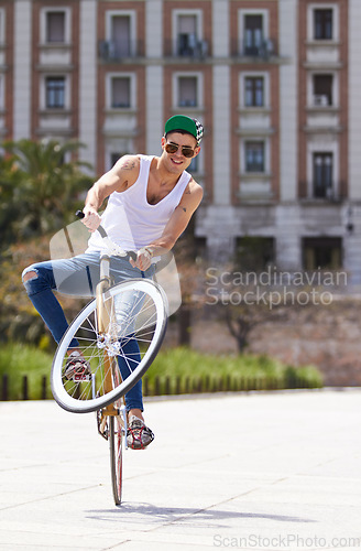 Image of Fitness, city and man riding a bicycle and practicing tricks and skills for a competition. Activity, hobby and casual young male person training and cycling outdoor with a bike in an urban town road.