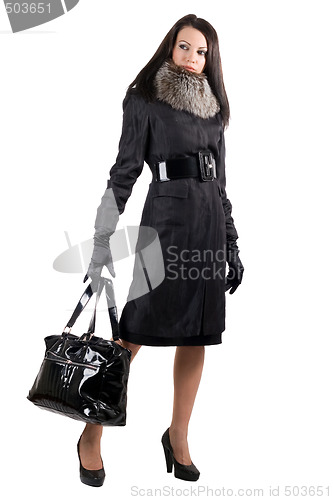Image of The young woman in a black coat with a bag. Isolated on white