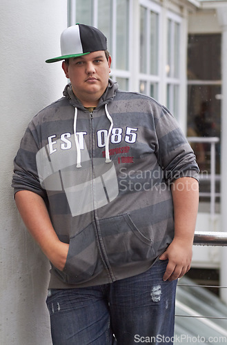 Image of Plus size, young guy and portrait outdoor with hipster and urban style feeling serious. Student, gen z fashion and cool clothing of a heavy male person with youth and confidence with hands in pocket