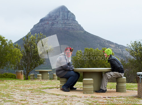 Image of Mountain, people and relax at table, bench or rest in nature, hike and hikers talking with view, landscape and natural beauty. Outdoor, mountains and man or friends in conversation in park and winter