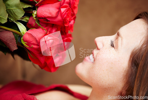 Image of Woman, smell roses and smile for valentines day gift, present and celebration of love, floral fragrance and bouquet. Happy female person, face and red flowers of plants in bloom, blossom and perfume