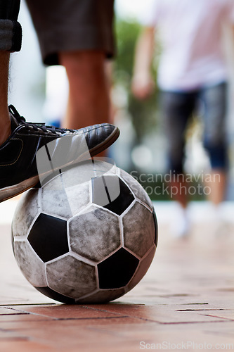 Image of Sports, street and feet of a person for soccer, game and training for athlete. City, sneakers and legs of a man with a football for sport, exercise and urban fitness in the road while playing a match