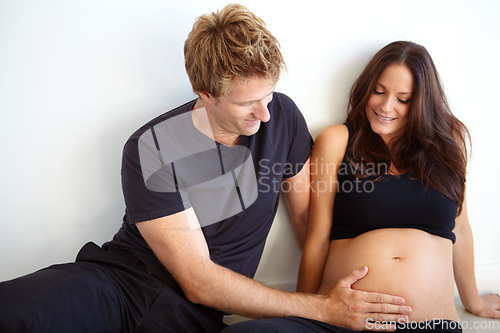Image of Pregnant, touching stomach and couple on a white background for love, care and support in studio. Future family, pregnancy and happy man and woman excited for bonding relationship, baby or parenthood