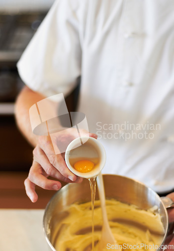 Image of Baker, baking process and egg in batter for cake, confectionery culinary skills and person in bakery kitchen. Closeup, food and chef cooking dessert, catering industry and mixing ingredients