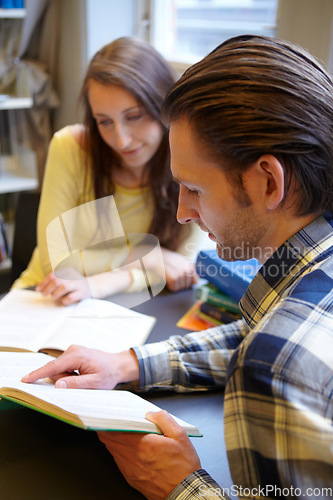 Image of Studying, man and woman reading book in library with education, learning together and research for project. University students, study group and people learn with textbook, knowledge and exam