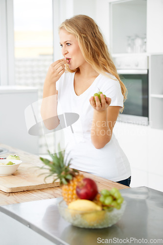 Image of Fruits, eating grapes or woman thinking of a healthy morning meal, lunch meal or diet in kitchen at home. Breakfast, wonder or vegan girl enjoying fruit salad or food bowl to lose weight for wellness