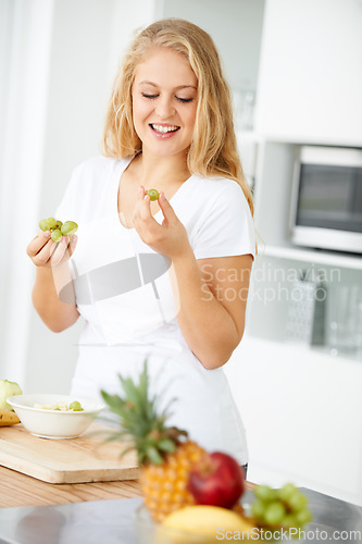 Image of Fruits, eating grapes or happy woman with healthy morning meal or lunch meal or diet in kitchen at home. Breakfast, smile or vegan girl enjoying a fruit salad or food bowl to lose weight for wellness