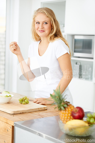 Image of Fruits, eating grapes or woman thinking of a snack, morning meal or healthy lunch diet in home kitchen. Breakfast idea, vegan or happy girl with fruit salad or food bowl to lose weight for wellness
