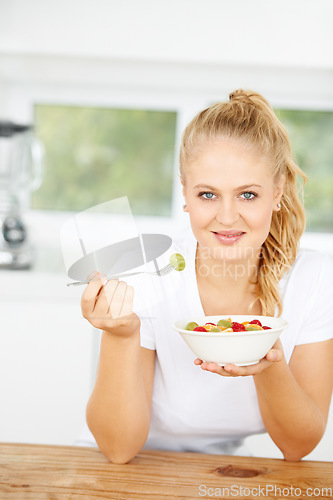 Image of Fruit salad, eating or portrait of happy woman with a snack, morning breakfast or lunch diet in home kitchen. Face, gut health or girl with fruits, grapes or food bowl meal to lose weight or wellness
