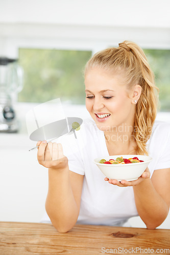 Image of Fruit salad, eating or happy woman with a snack, morning breakfast or lunch diet in home kitchen. Smile, gut health or vegan girl with fruits, grapes or food bowl meal to lose weight or wellness