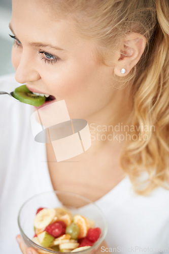 Image of Kiwi, eating or happy woman with fruit salad, morning breakfast meal or lunch diet in home kitchen. Smile, gut health or vegan girl with fruits, vitamin c or food bowl to lose weight for wellness