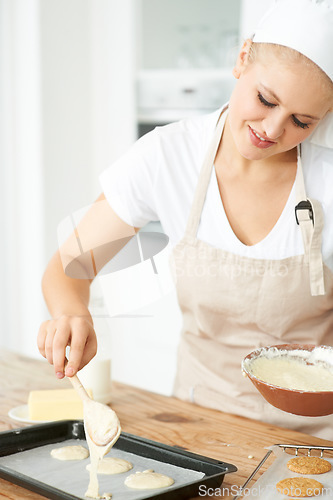 Image of Happy woman, tray or chef baking cookies with dough or pastry in a bakery kitchen with recipe. Food business, dessert or girl baker smiling or working in preparation of a sweet meal, cake or biscuit