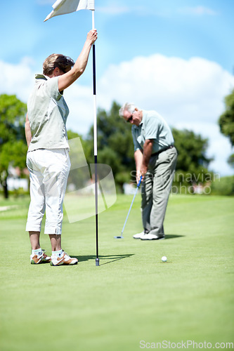 Image of Woman with flag, old man or golfer on golf course for a birdie, putting stroke or exercise in retirement. Senior couple, mature or serious player training in golfing sports game driving with a club